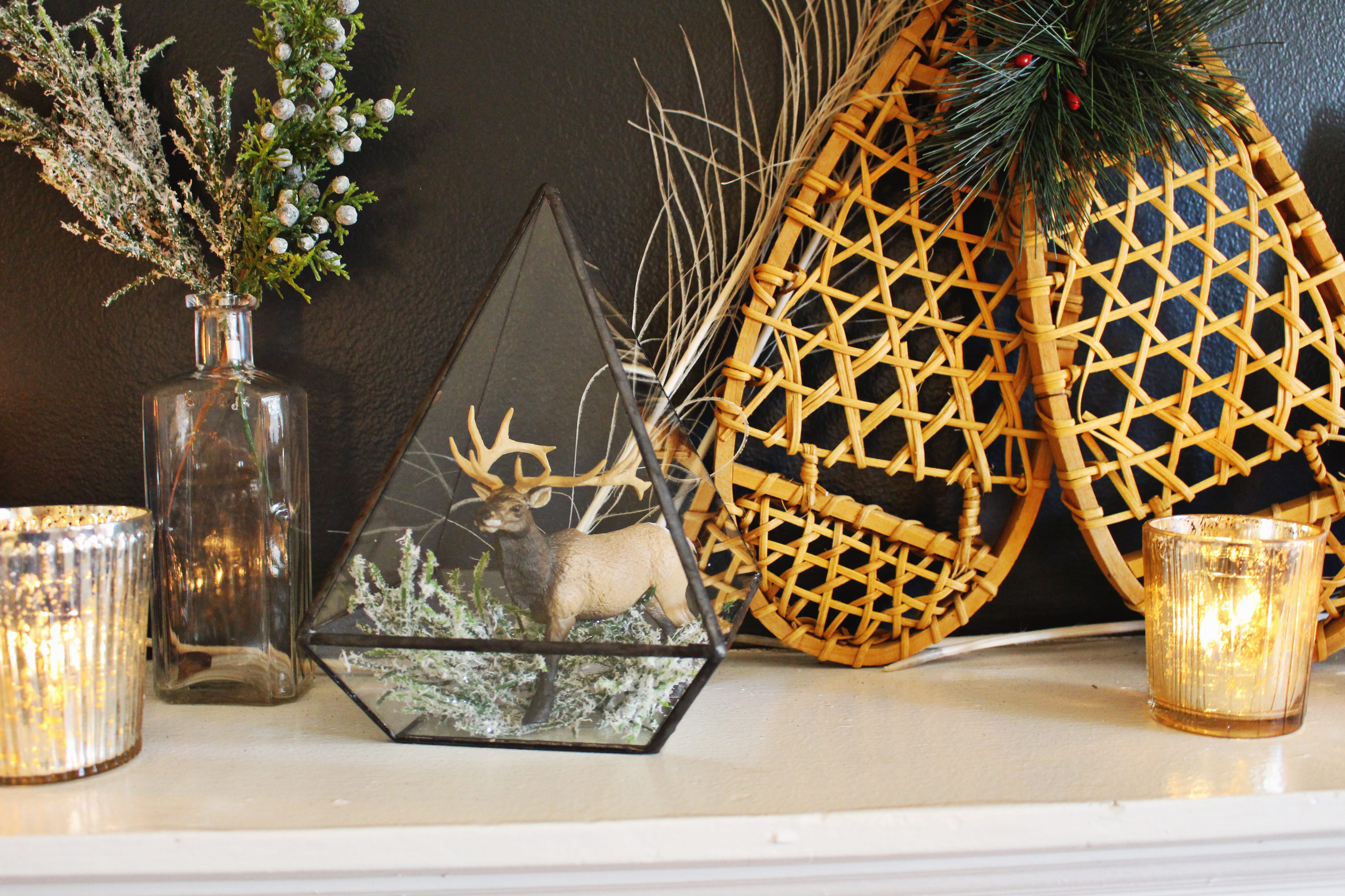 Place a toy moose with some greenery in a little glass prism for chic, woodsy mantel decor