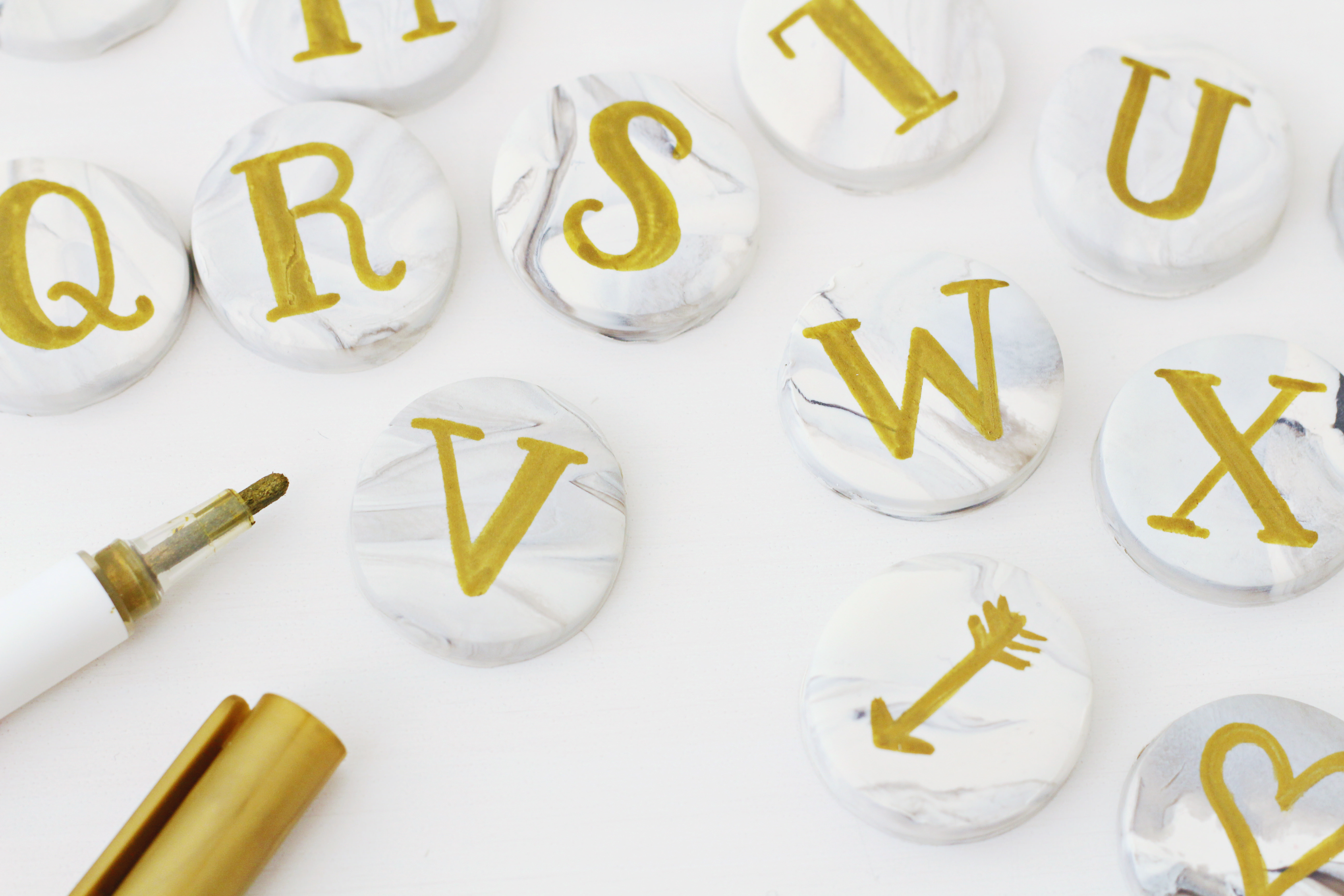 Use a gold paint pent to hand letter your marble clay magnets