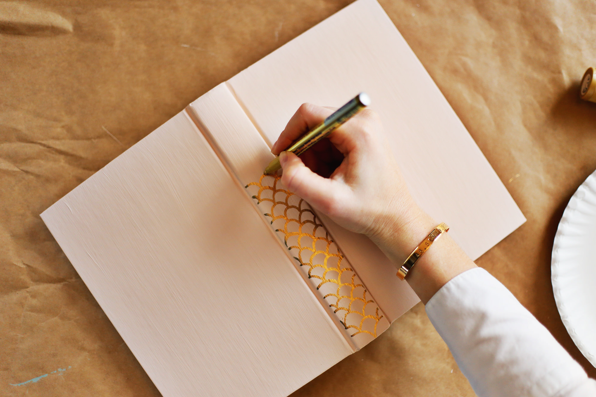 Recycle old, unattractive books by painting them! Add classic detail to the spine with a gold paint pen.