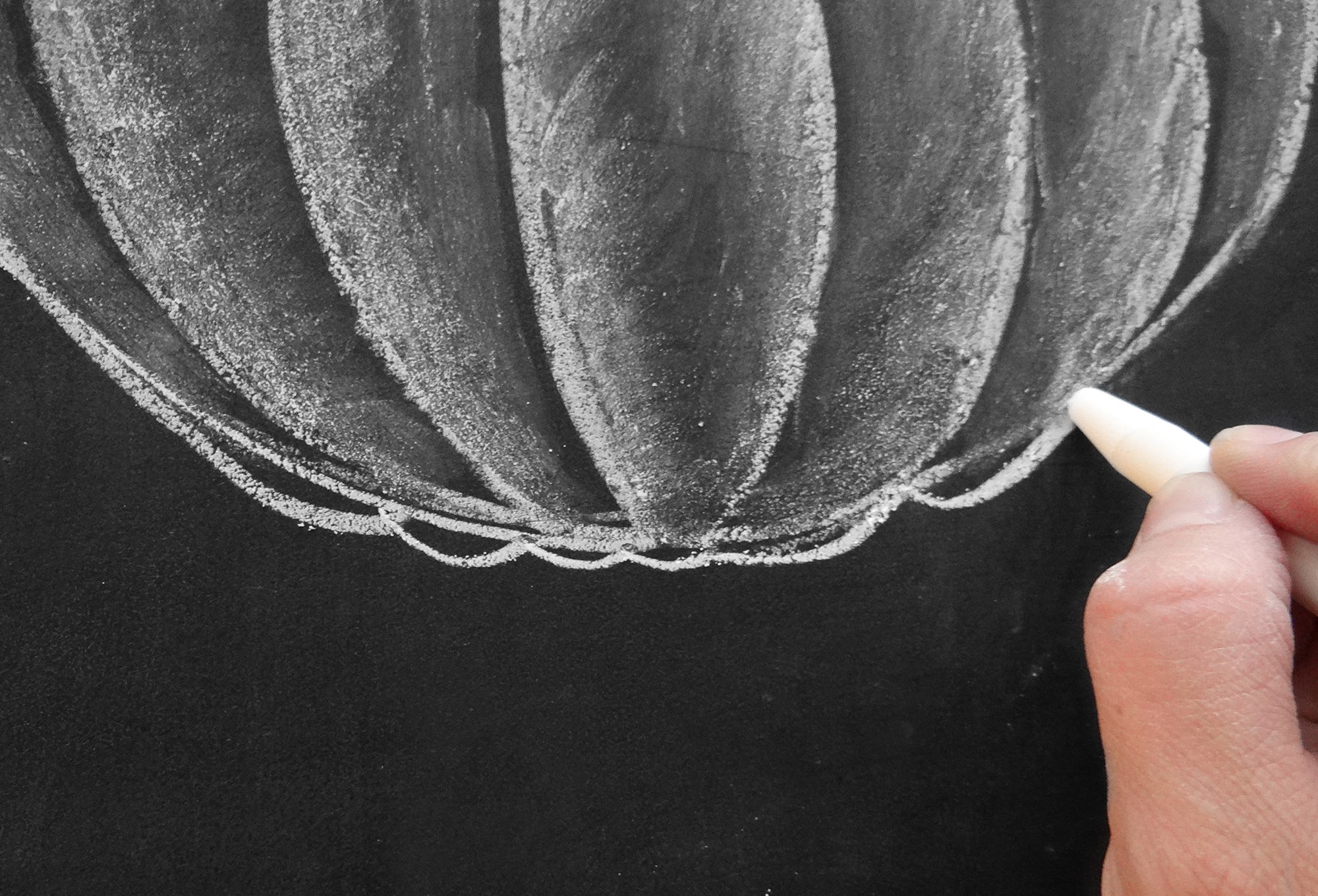 Valerie McKeehan, author of The Complete Book of Chalk Lettering, gives a step-by-step tutorial on how to draw a chalk pumpkin.