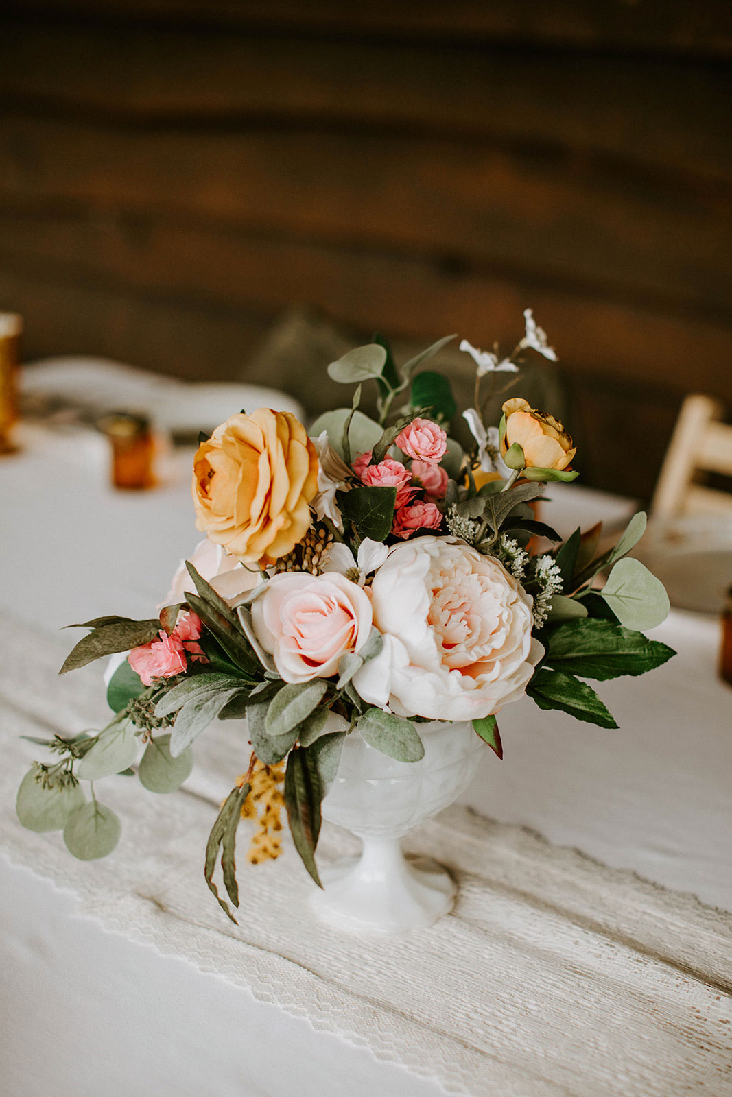 faux floral arrangement in a milk glass compote