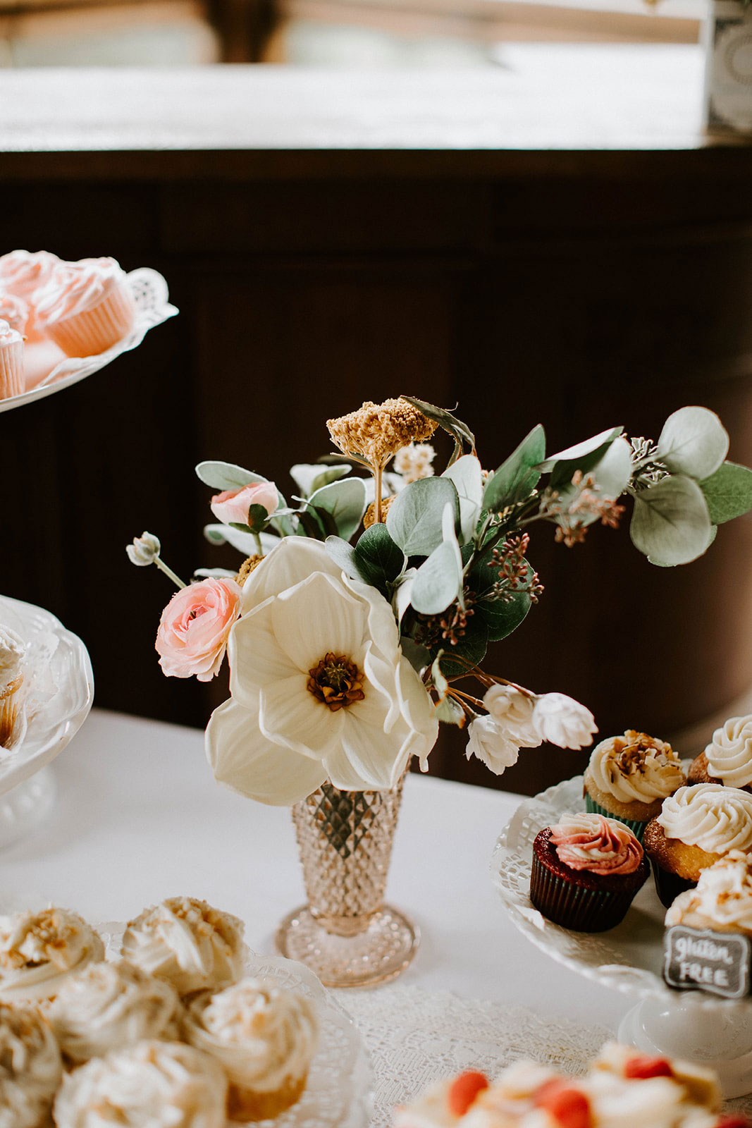 faux floral arrangement in vintage glass vase